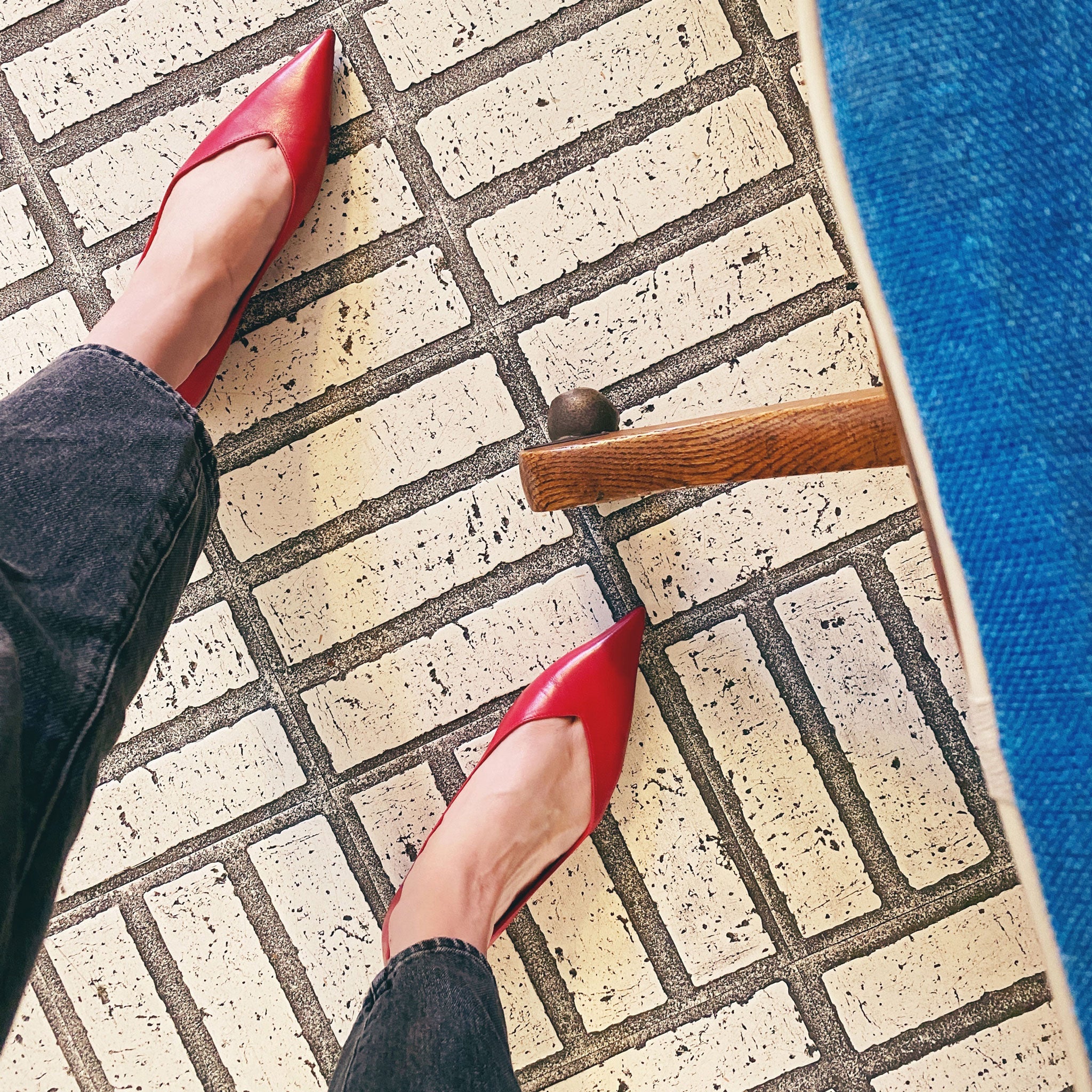 very pointy flat shoes made of leather in a bright lipstick red color.