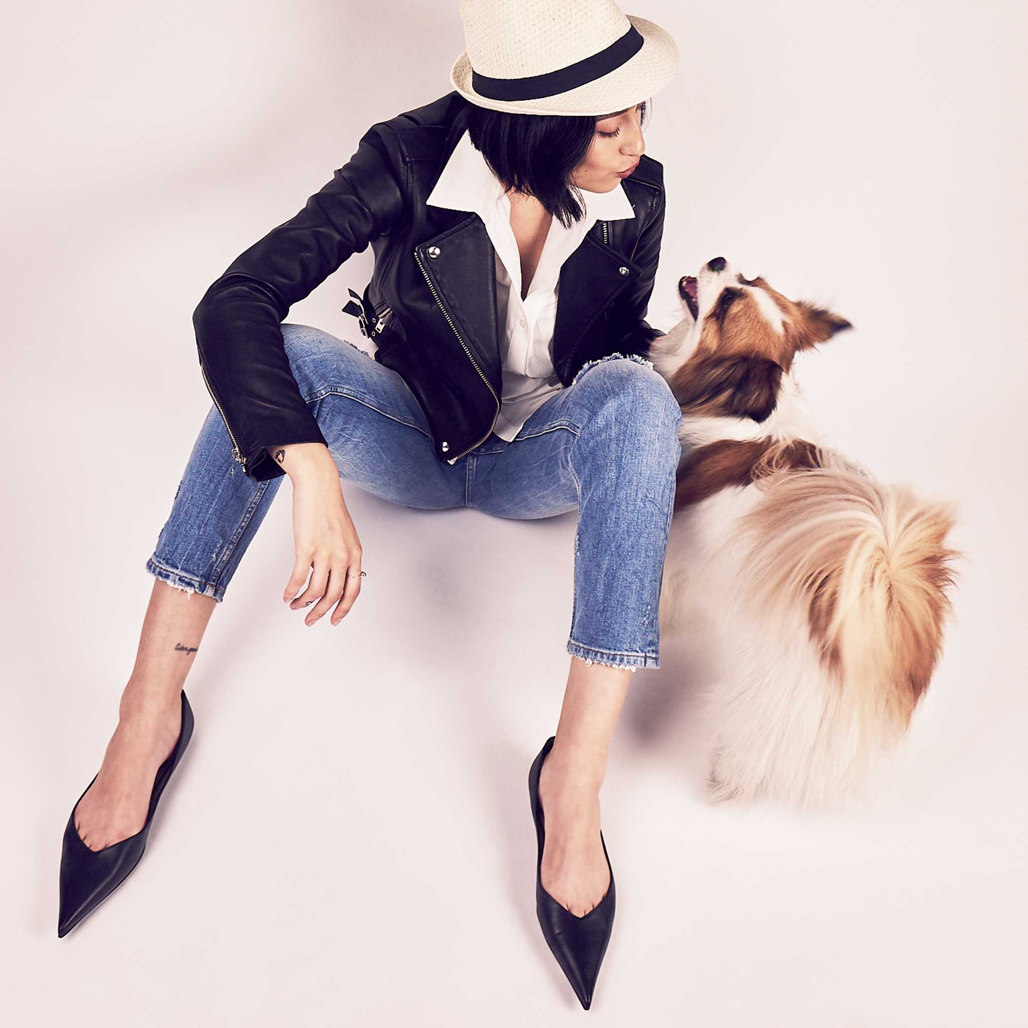female with small dog and pointed flat black leather shoes