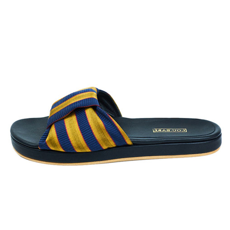 Gold and navy striped sandal with striped bow tie at vamp. Leather footbed is contoured with leather outsole.