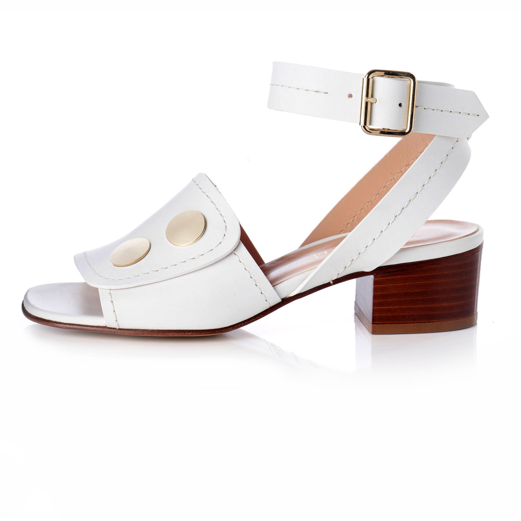 white open toe sandals with ankle strap and gold buckle detail. round oversized metal flat studs at vamp with brown stacked wood heel.